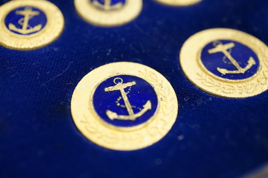 A cased set of enamelled naval buttons and similar keyrings